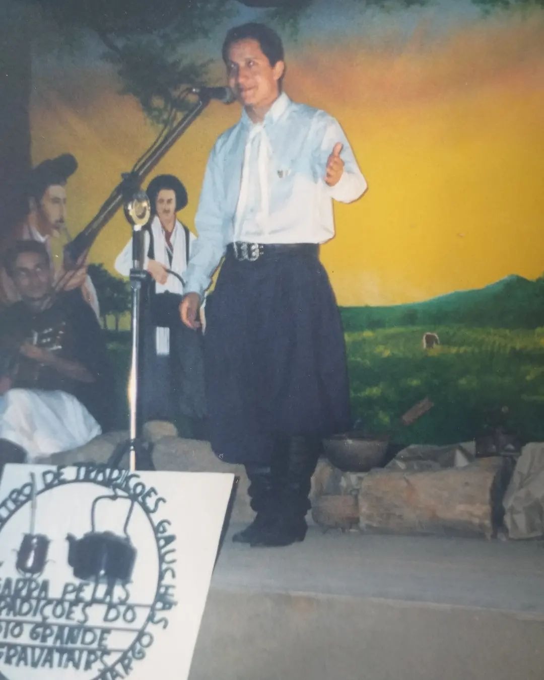Patrão no palco com estandarte do CTG
